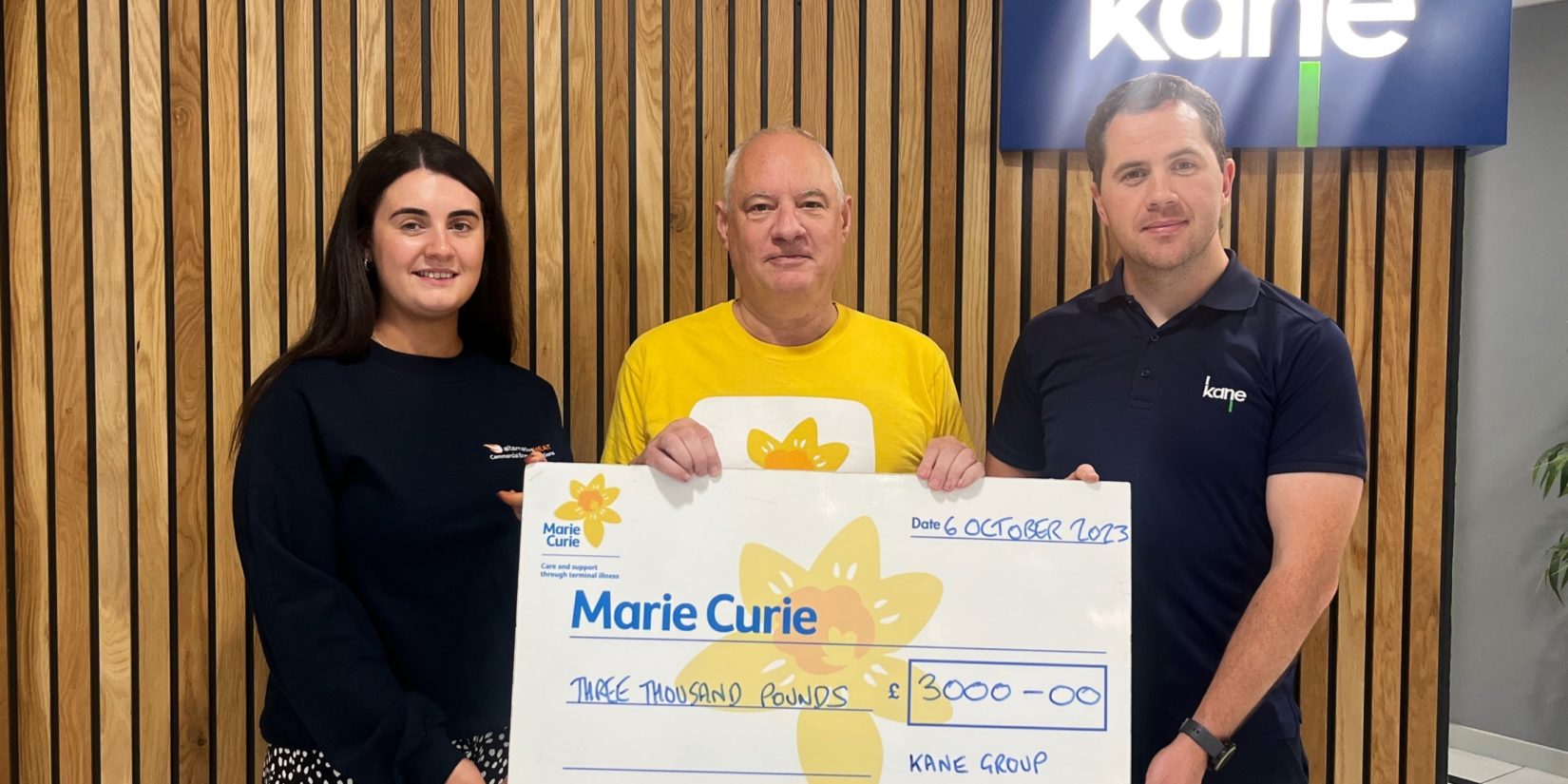 Pictured above, Lauren McEvoy (left) from Alternative Heat and Noel McPolin (right) from Kane, present Phil Kane (Centre) from Marie Curie with a cheque for £3000.