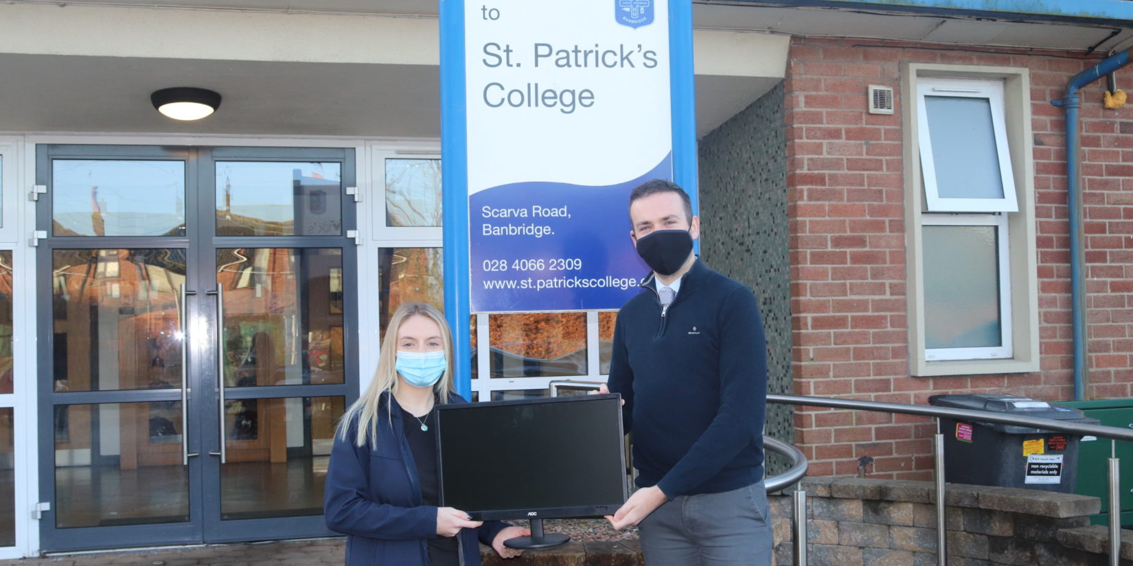 Pictured: Sarah Keown, Business Systems Administrator presenting the monitors to Ryan McCabe of St Patricks College.
